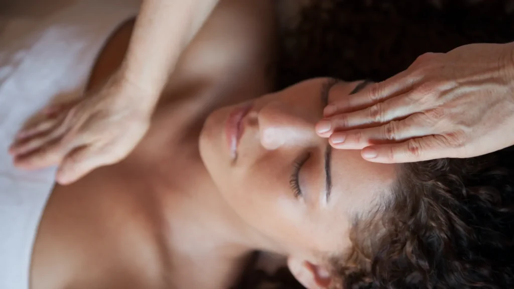 Mujer recibiendo un masaje consciente en Girona, con un gesto de calma y entrega